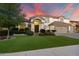 Beautifully landscaped two-story home featuring a lush green lawn and a three-car garage at 1001 N Peppertree Dr, Gilbert, AZ 85234