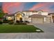 Elegant two-story home with a well-manicured lawn, complemented by desert landscaping and a three-car garage at 1001 N Peppertree Dr, Gilbert, AZ 85234