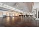 Large, versatile hall with dark wood floors, chandeliers, and classic architectural details at 1001 N Peppertree Dr, Gilbert, AZ 85234