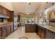 Spacious kitchen featuring custom wood cabinetry, stainless steel appliances, and a center island for extra workspace at 1001 N Peppertree Dr, Gilbert, AZ 85234
