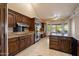 Gourmet kitchen with dark wood cabinets, granite countertops, and state-of-the-art appliances at 1001 N Peppertree Dr, Gilbert, AZ 85234