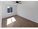 Bright bedroom featuring a ceiling fan, a large window, and wood-look flooring at 1019 N 62Nd Ave, Phoenix, AZ 85043