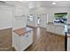 Spacious open kitchen features white cabinetry, and wood-look tile flooring, seamlessly connecting living areas at 1019 N 62Nd Ave, Phoenix, AZ 85043