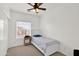 Bright bedroom features a ceiling fan, a window with blinds and a single bed with a side table at 10539 W Tamara Dr, Casa Grande, AZ 85193
