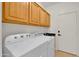 Convenient laundry room boasts overhead cabinets, a utility sink, and modern washer and dryer units at 10539 W Tamara Dr, Casa Grande, AZ 85193