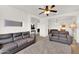 Comfortable living room with neutral carpet, a ceiling fan, and modern design details at 10539 W Tamara Dr, Casa Grande, AZ 85193