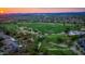 Panoramic aerial view of McDowell Mountain Golf Club at sunset featuring lush green fairways and manicured greens at 10875 E Mirasol Cir, Scottsdale, AZ 85255