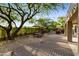 Charming backyard with stone patio, outdoor dining area, and a mature shade tree at 10875 E Mirasol Cir, Scottsdale, AZ 85255