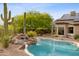 Relaxing backyard pool featuring a waterfall feature, mature cacti, and built-in spa at 10875 E Mirasol Cir, Scottsdale, AZ 85255