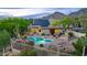 Inviting backyard pool area with lush landscaping, solar panels, and mountain backdrop at twilight at 10875 E Mirasol Cir, Scottsdale, AZ 85255