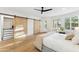 Light-filled bedroom has hardwood floors, a ceiling fan, and sliding closet doors at 10875 E Mirasol Cir, Scottsdale, AZ 85255