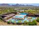 Aerial view of a large community pool area with multiple pools, water slides, and lounging areas at 10875 E Mirasol Cir, Scottsdale, AZ 85255