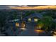 Aerial view of beautiful two-story home, showcasing a three-car garage and desert landscaping at dusk at 10875 E Mirasol Cir, Scottsdale, AZ 85255