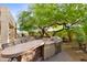 Well-equipped outdoor kitchen with countertop, grill, and dining seating; perfect for entertaining at 10875 E Mirasol Cir, Scottsdale, AZ 85255