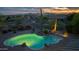 Aerial view of pool area featuring desert landscaping and a small waterfall under colorful dusk sky at 10875 E Mirasol Cir, Scottsdale, AZ 85255