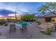 Inviting pool area with lounge chairs, solar panels on roof, and verdant desert landscaping at dusk at 10875 E Mirasol Cir, Scottsdale, AZ 85255
