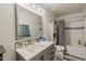 A full bathroom with gray cabinetry, shower and tub combo, and well-lit vanity area at 1109 E San Pedro Ave, Gilbert, AZ 85234