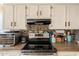 Updated kitchen with stainless steel appliances, dark countertops and white cabinets and mosaic backsplash at 1109 E San Pedro Ave, Gilbert, AZ 85234