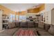 Open-concept living space features a large sofa, kitchen, and dining area with natural light at 1109 E San Pedro Ave, Gilbert, AZ 85234