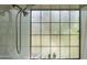A beautiful walk-in shower with subway tiles, mosaic details, and large grid style window at 1109 E San Pedro Ave, Gilbert, AZ 85234