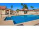 Beautiful community pool with lounge chairs and umbrellas under a blue sky at 1120 N Val Vista Dr # 110, Gilbert, AZ 85234