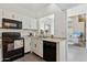 Efficient kitchen features white cabinets, black appliances, and eat-through counter at 1126 W Elliot Rd # 1066, Chandler, AZ 85224