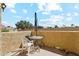 Outdoor patio with stucco walls, table and chairs, and bright sky at 1126 W Elliot Rd # 1066, Chandler, AZ 85224