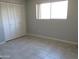 Cozy bedroom featuring tile flooring, a bright window, and a spacious closet at 1130 E Butler Dr # B4, Phoenix, AZ 85020