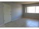 A well-lit living room with tile flooring, neutral wall color, and a large bright window at 1130 E Butler Dr # B4, Phoenix, AZ 85020