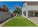 The manicured backyard has an artificial lawn, privacy fence, and a covered patio space at 1131 E Bishop Dr, Tempe, AZ 85282