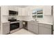 Well-lit kitchen featuring stainless steel appliances, quartz countertops, and ample cabinet storage at 1131 E Bishop Dr, Tempe, AZ 85282