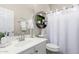 Well-lit bathroom featuring a modern vanity, decorative mirror, and shower with stylish curtain at 1324 S Banning St, Gilbert, AZ 85296