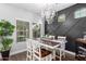 Stylish dining room features a modern chandelier, decorative wall paneling, and a chic bar area, perfect for entertaining guests at 1324 S Banning St, Gilbert, AZ 85296