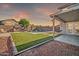 Relaxing backyard featuring a pool, comfortable seating, and low-maintenance turf at 13625 W Peck Ct, Litchfield Park, AZ 85340