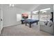 Bright game room featuring pool table, large windows, and vaulted ceiling, great for entertainment at 13625 W Peck Ct, Litchfield Park, AZ 85340