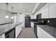 Modern kitchen with stainless steel appliances, granite countertops, and stylish black accents at 13625 W Peck Ct, Litchfield Park, AZ 85340