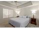 Inviting bedroom with a ceiling fan, tray ceiling, and side tables with lamps on either side of the bed at 13805 N Hamilton Dr # H102, Fountain Hills, AZ 85268