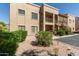A ground-level shot of a two-story condo with desert landscaping and exterior stairs at 13805 N Hamilton Dr # H102, Fountain Hills, AZ 85268