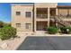 Two-story condo with a beige exterior, front porch, exterior stairs, and desert landscaping at 13805 N Hamilton Dr # H102, Fountain Hills, AZ 85268