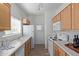 Efficient kitchen showcases white appliances, wooden cabinets, ample counter space, and wood-look tile flooring at 13805 N Hamilton Dr # H102, Fountain Hills, AZ 85268