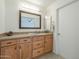 Bright bathroom with wooden vanity, stone countertop, and neutral colors at 14110 W White Rock Dr, Sun City West, AZ 85375