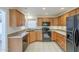 Well-lit kitchen featuring wooden cabinets, black appliances, and tile flooring at 14110 W White Rock Dr, Sun City West, AZ 85375