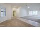 Bright living room featuring large windows, a ceiling fan, and neutral carpeting at 14110 W White Rock Dr, Sun City West, AZ 85375