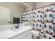 Modern bathroom featuring a white sink, quartz countertop, and a colorful geometric shower curtain at 1421 W Saltsage Dr, Phoenix, AZ 85045