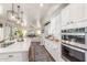 Modern kitchen with white cabinets, stainless steel appliances, and a view into the living room at 1421 W Saltsage Dr, Phoenix, AZ 85045