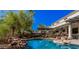 Resort-style pool area boasts rock features, a waterfall, and a view of the home's elegant backyard design at 1421 W Saltsage Dr, Phoenix, AZ 85045