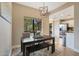Bright dining area with modern chandelier, wood floors, and view to laundry and kitchen areas at 15050 N Thompson Peak Pkwy # 2072, Scottsdale, AZ 85260