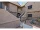 Exterior of a residential building featuring staircases and desert landscaping with gravel and mature plants at 15050 N Thompson Peak Pkwy # 2072, Scottsdale, AZ 85260