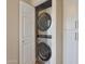 Modern stackable washer and dryer with white closet doors and built-in shelving at 15050 N Thompson Peak Pkwy # 2072, Scottsdale, AZ 85260