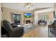 Spacious living room with a fireplace, ceiling fan, sliding glass door to balcony, and wood floors at 15050 N Thompson Peak Pkwy # 2072, Scottsdale, AZ 85260